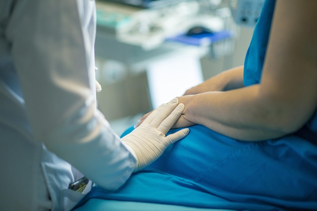 A medical professional touching the hand of their patient.