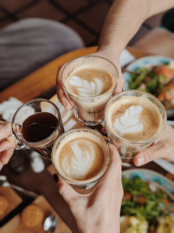 People with four glasses of coffees making a toast