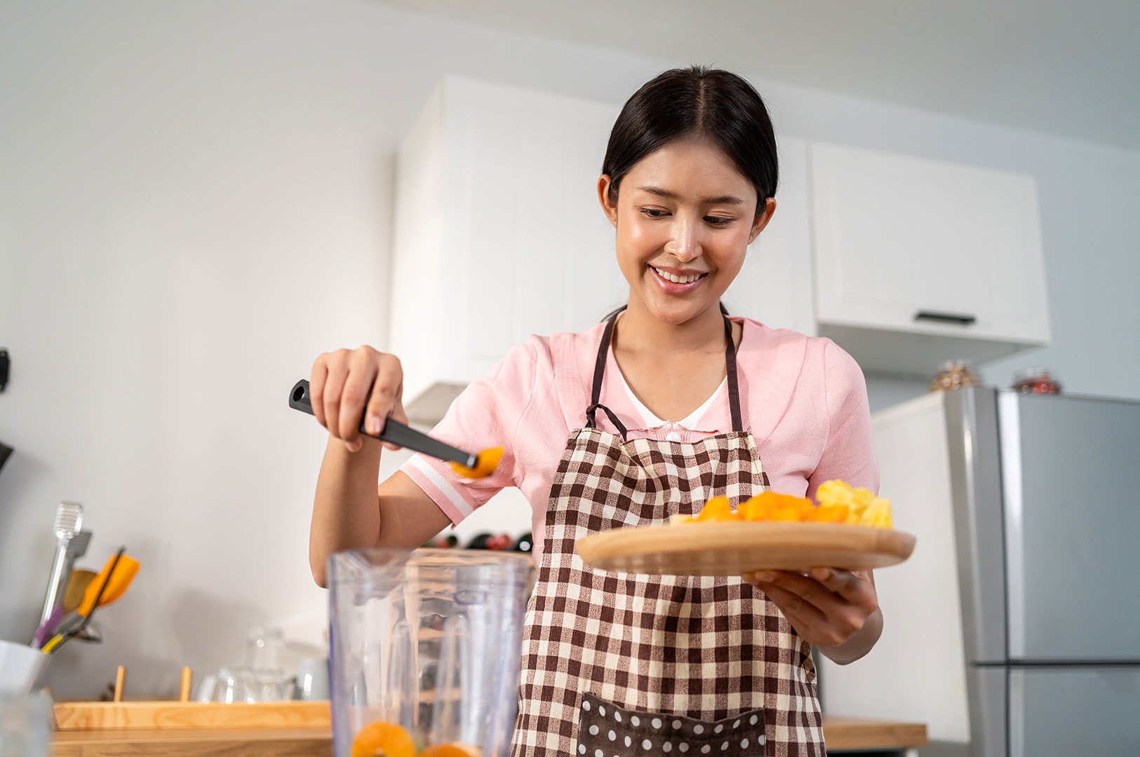 Domestic helper preparing food in a home kitchen.