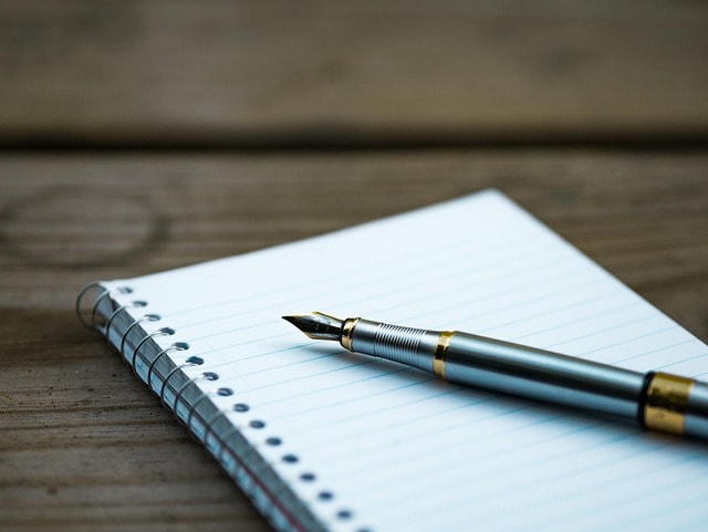 A pen and a notebook capturing the idea of writing.