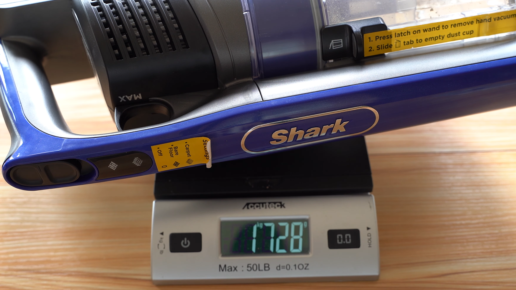 Shark iz340h cordless vacuum being weighed after collecting sand from hardwood
