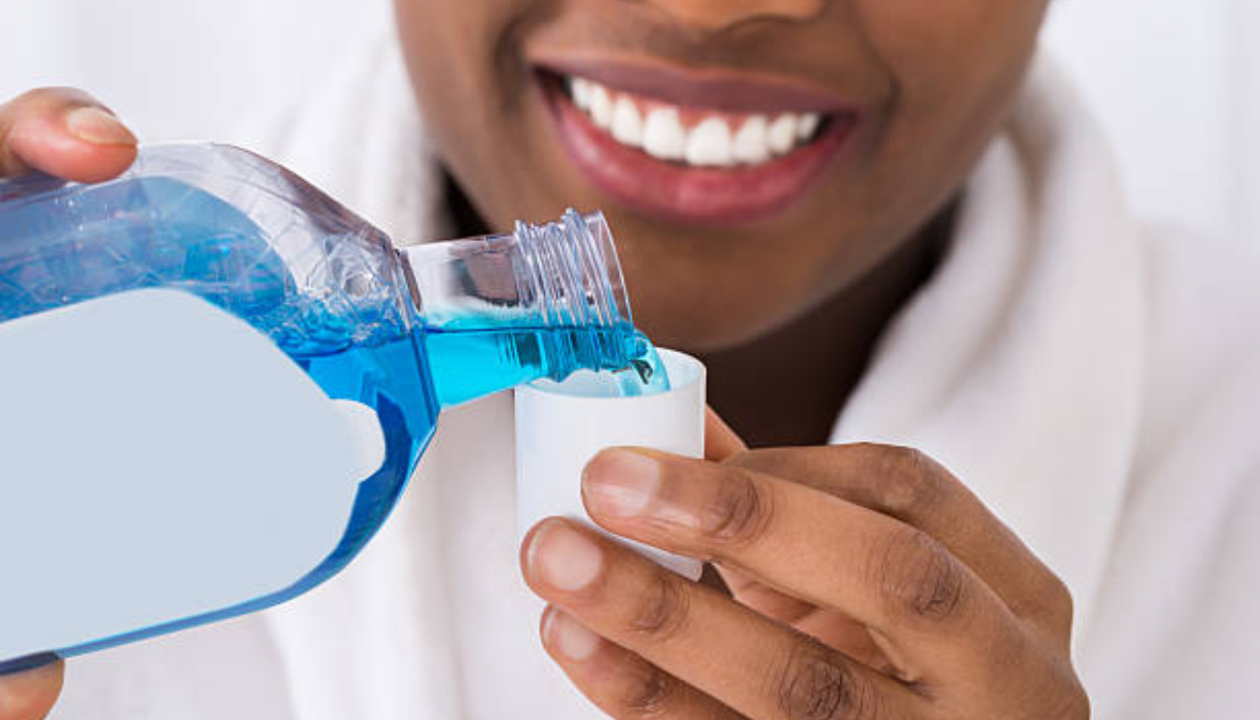 Person heller blå munnskyllevæske i et målebeger før bruk for munn- og tannhygiene. flux munnskyll 500 ml voksne og barn barn over 12 år hull i tennene flux 12 år 0,2 naf skyll munnen aqua glycerin sodium fluoride munnskyll 1 2 ganger legg fluor produkter 0,2 fluorskyll coolmint tenner smak mint pris bruk varenummer kjøp god tennene innhold gir munnen skyll frisk karies høyt fluorinnhold styrke praktisk inneholder ingredienser minutt xylitol