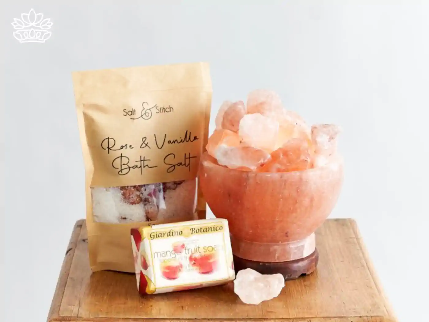 A set of self-care items, including rose and vanilla bath salts, mango fruit soap, and a bowl of Himalayan salt crystals, arranged neatly on a wooden surface. Fabulous Flowers and Gifts at the end. Gift Boxes for Girlfriend. 