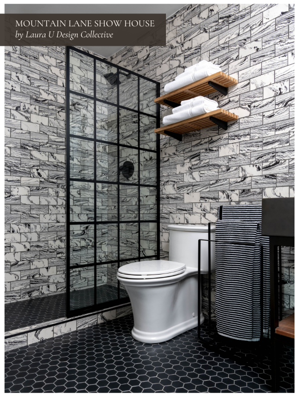a bold secondary bath with white and black walls that complement the other color palette throughout the home