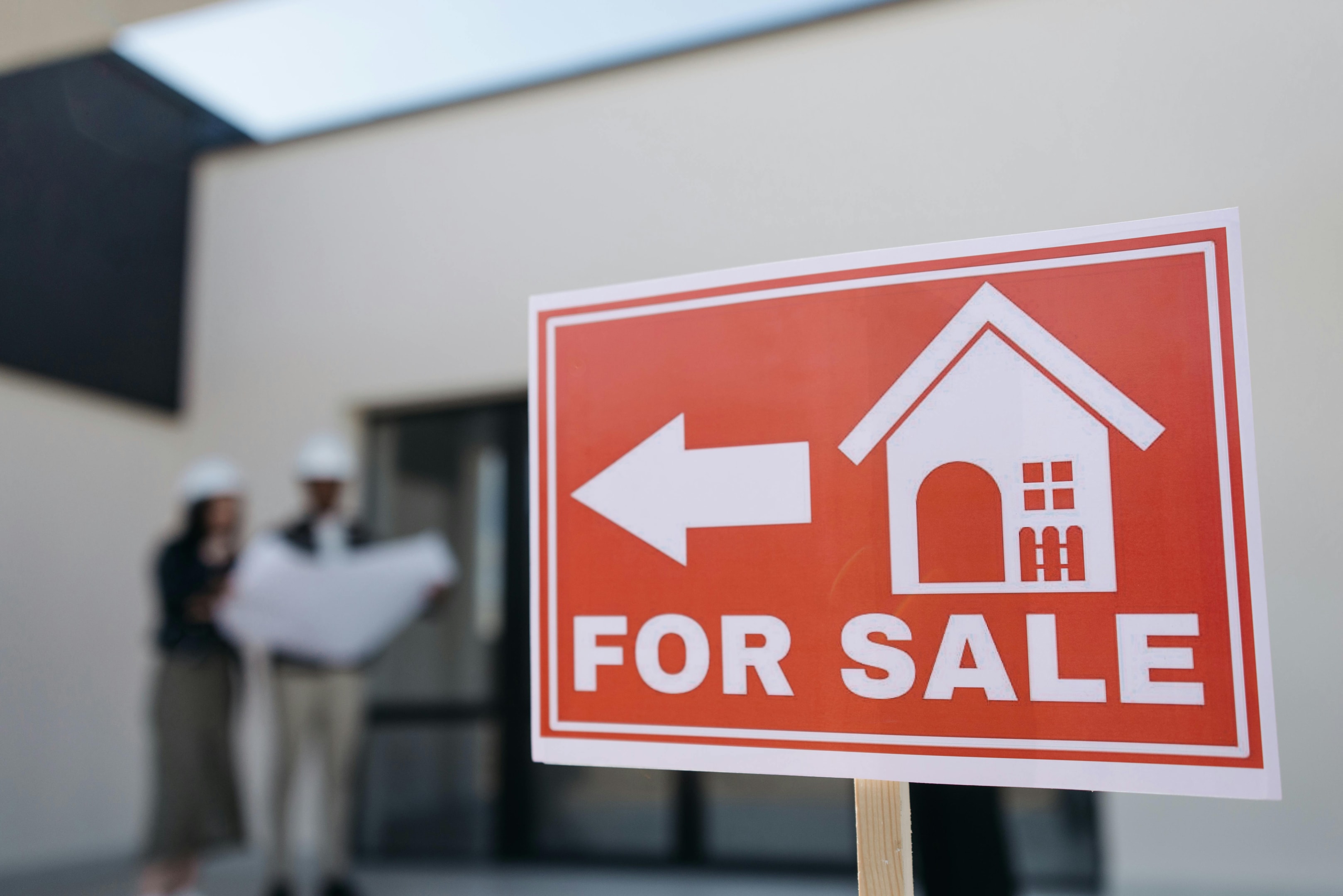 For Sale sign being placed in front of home.