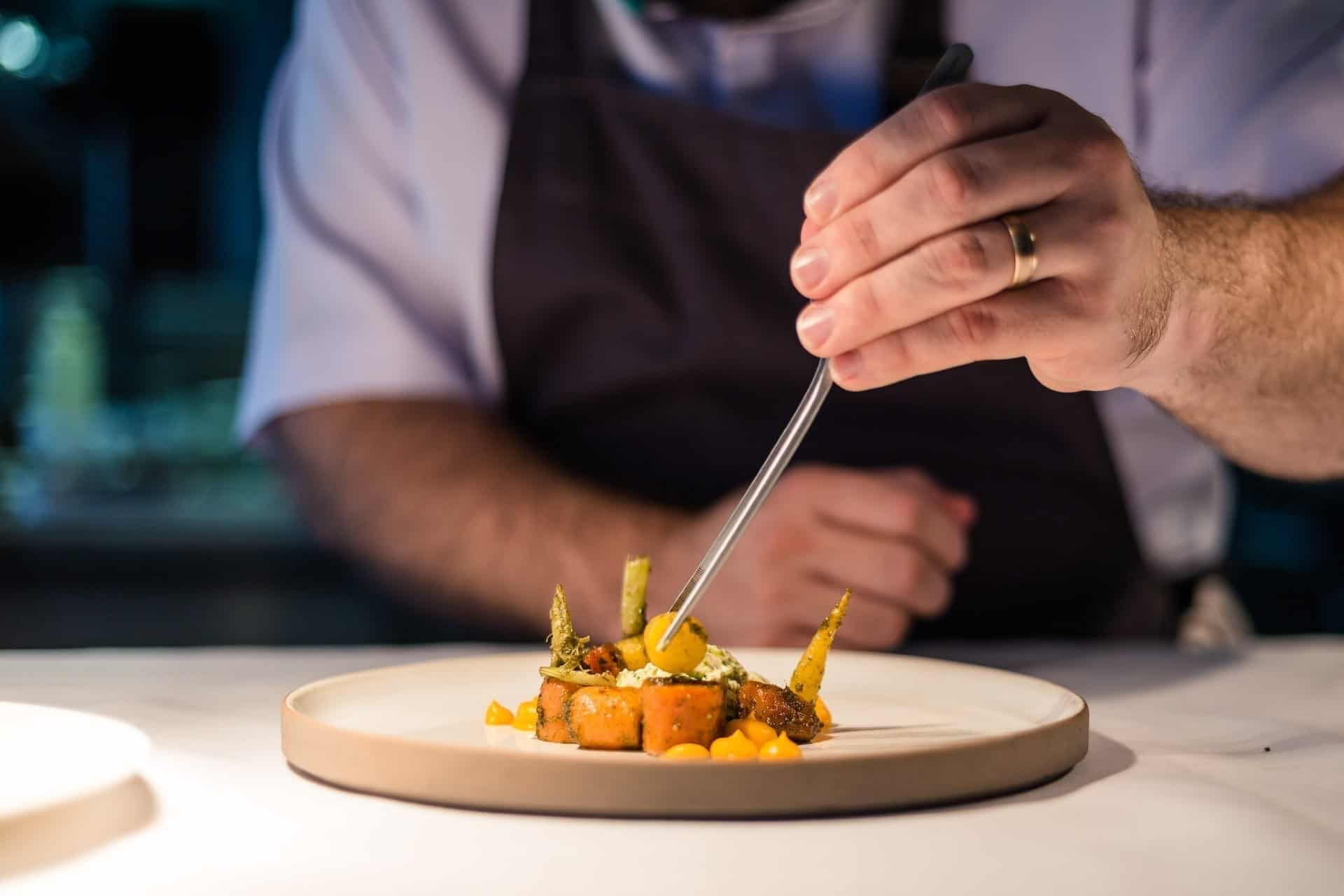 A chef preparing food at Restaurant James Sommerin in Penarth