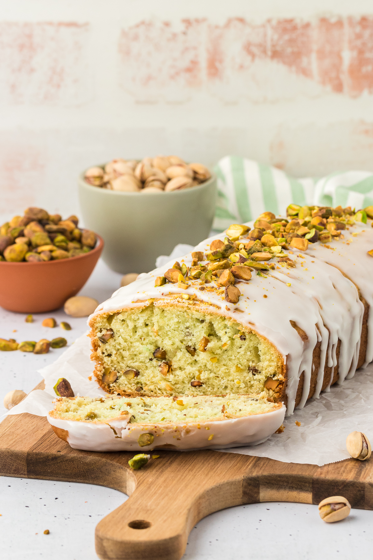 sliced pistachio quick bread on wood cutting board