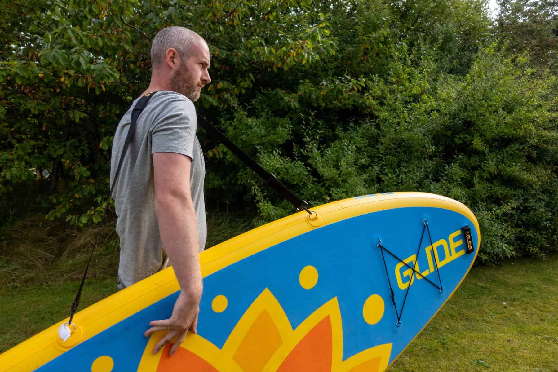 man carrying a paddle board