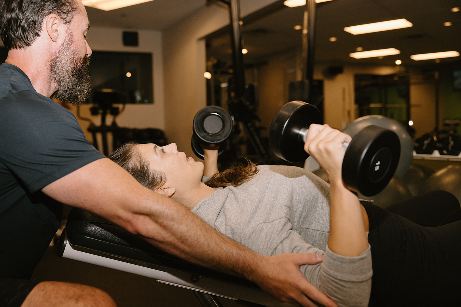 A personal trainer and a client discussing fat loss with resistance training
