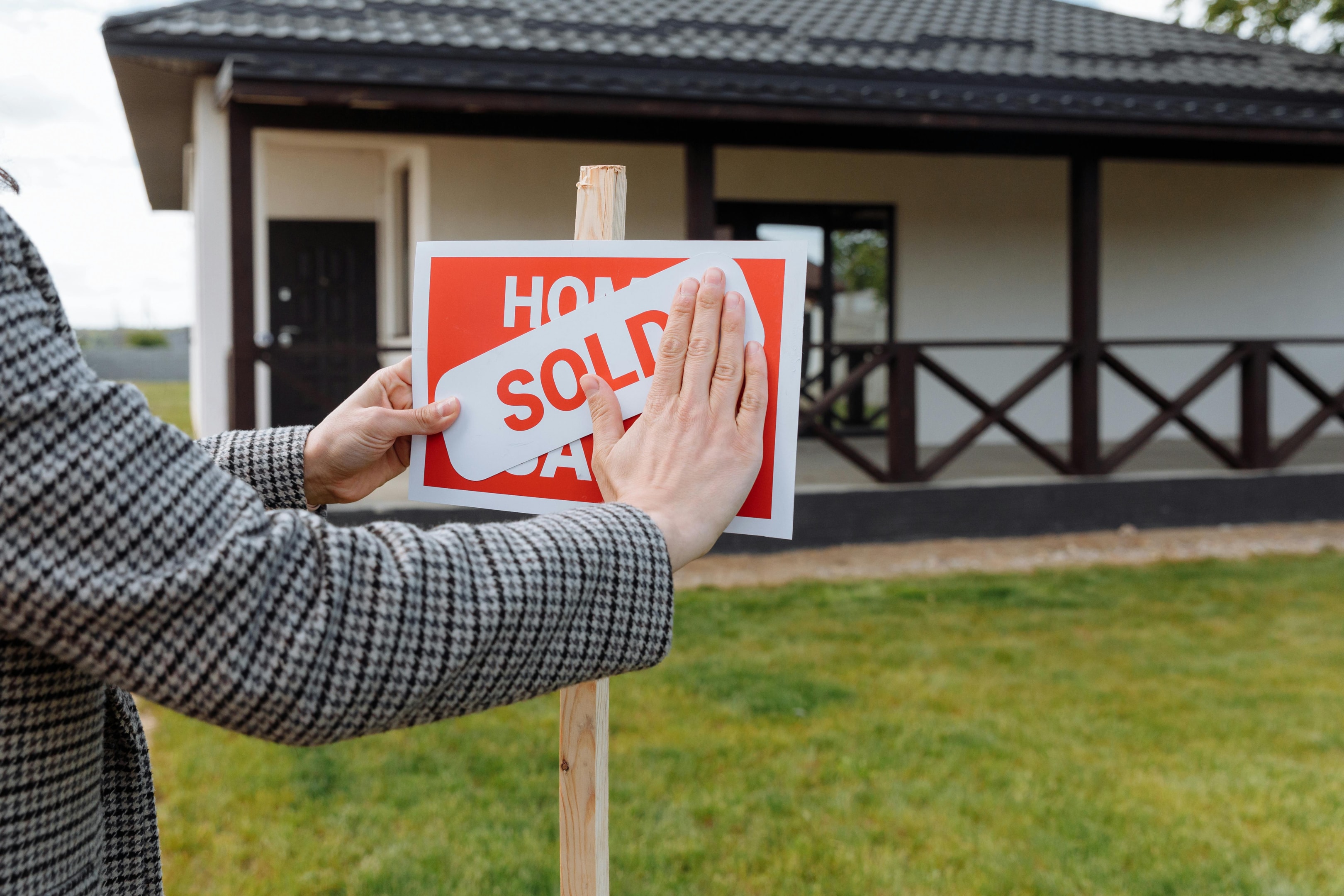 Sold sign being placed in front of recently purchased property. 