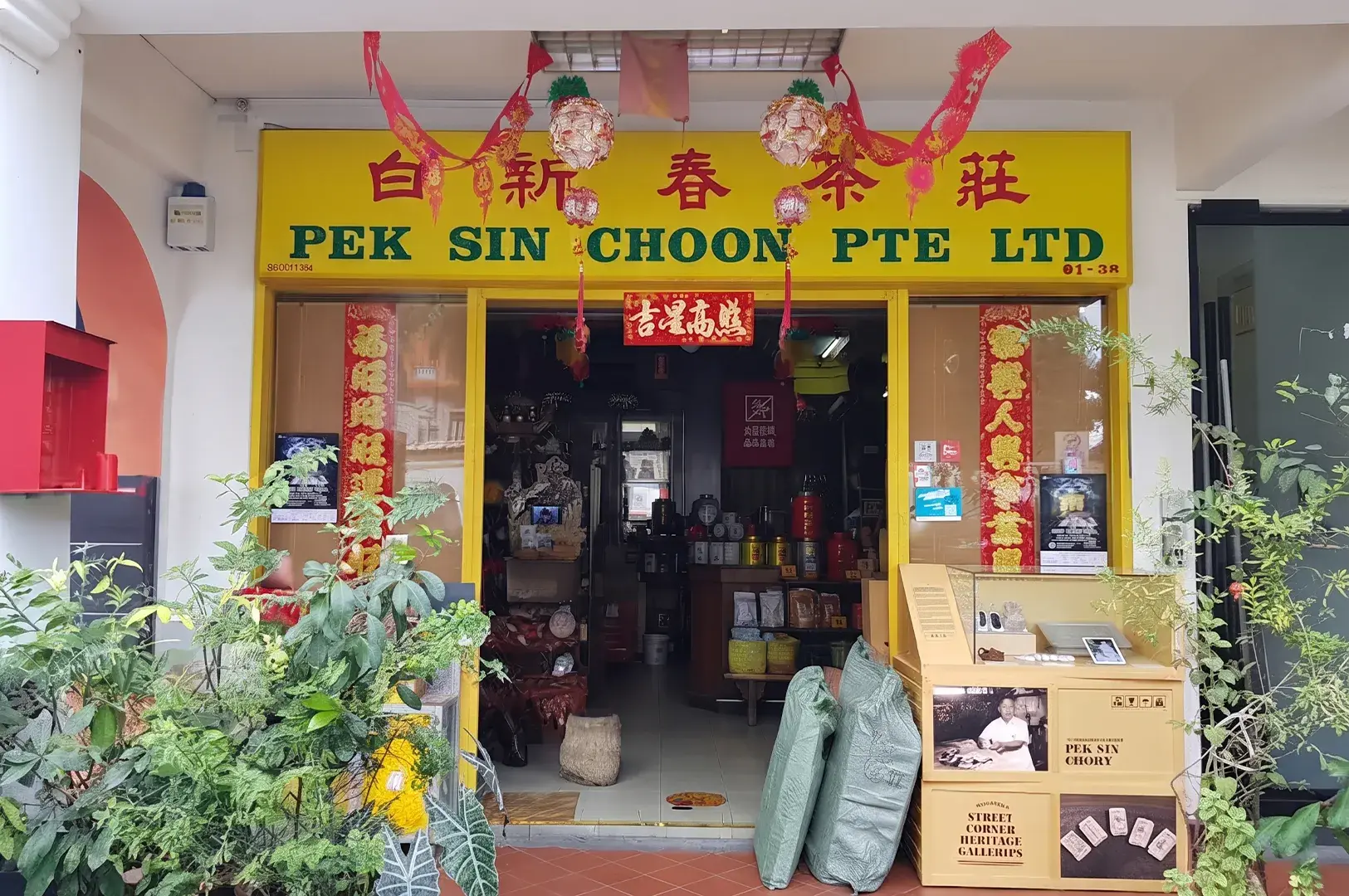 Storefront of heritage tea shop Pek Sin Choon with yellow signage and Chinese banners.