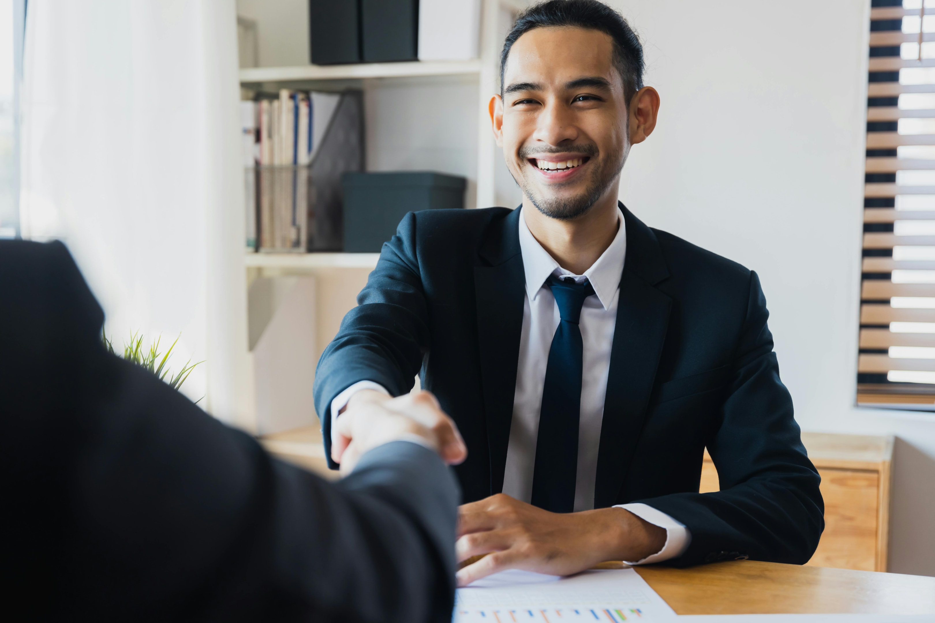 Real estate investor shakes hand of banker after signing DSCR loan.
