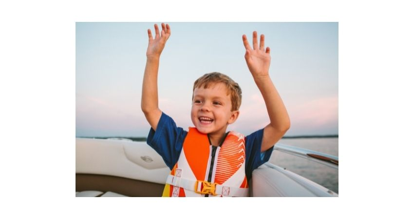 child wearing life jacket while sailing