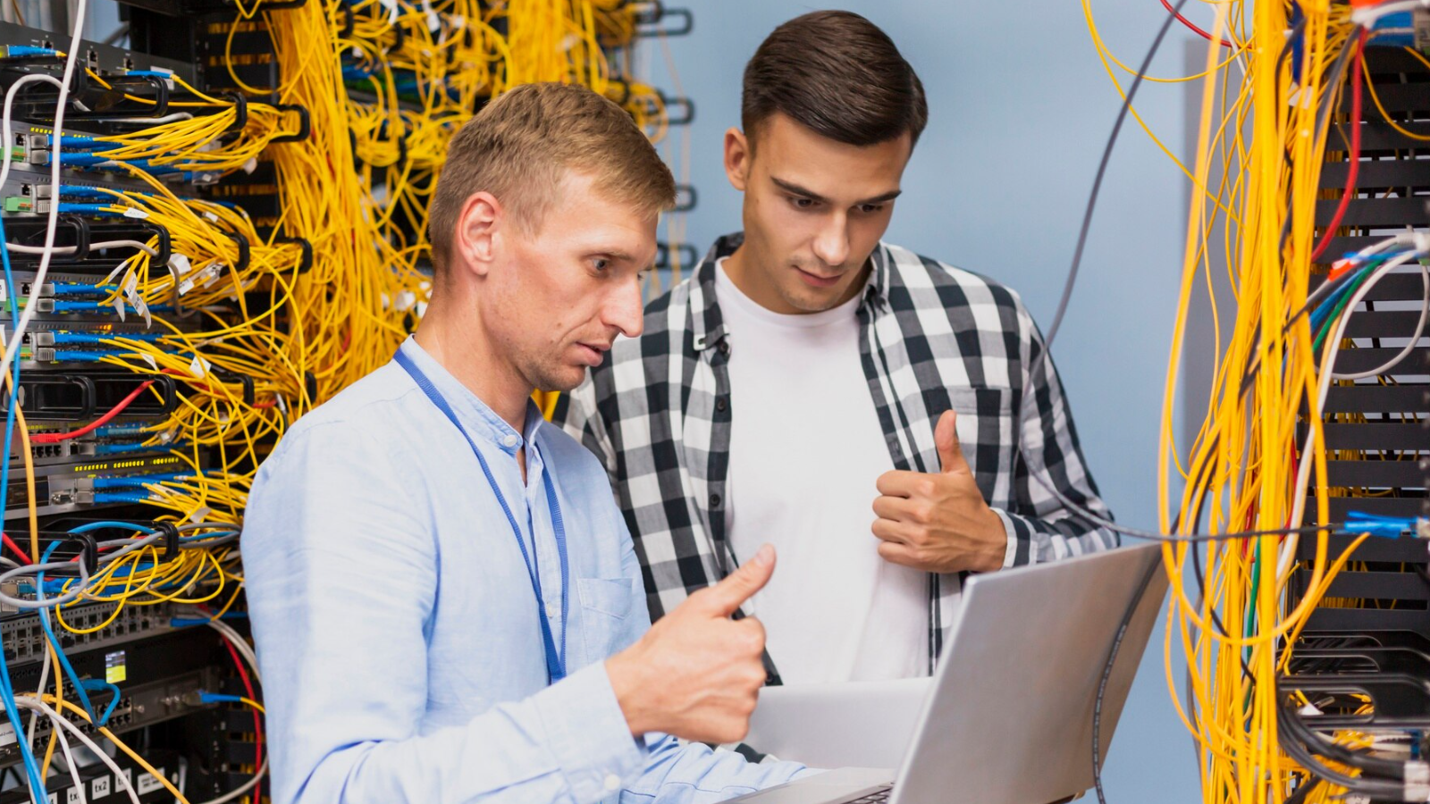 IT team analyzing network infrastructure and technologies in a server room to support security, critical applications, and enterprise network management.