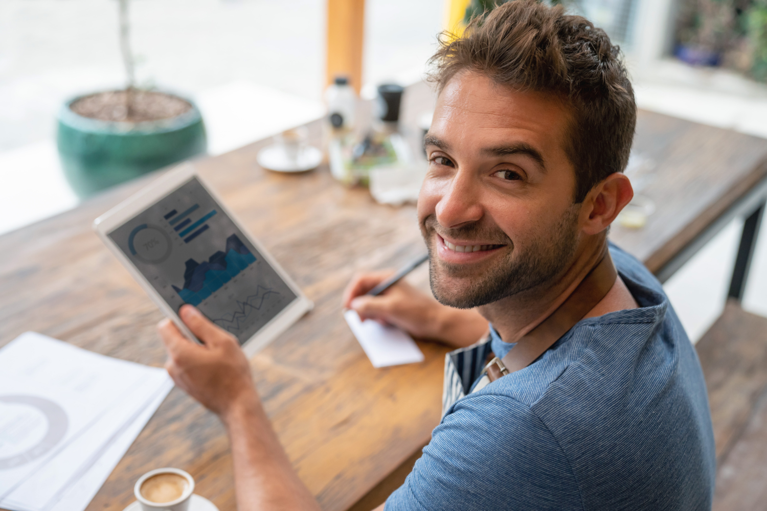 Business owner holding a tab with graphs.