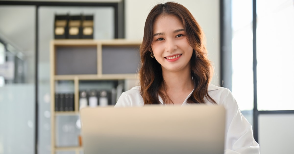 Confident woman at her desk, utilizing top tax resources for OnlyFans creators on her laptop.