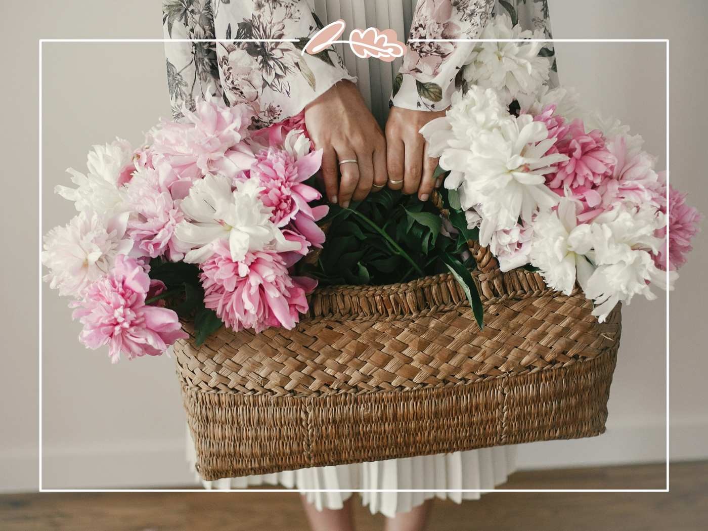 Person holding a basket filled with pink and white flowers.