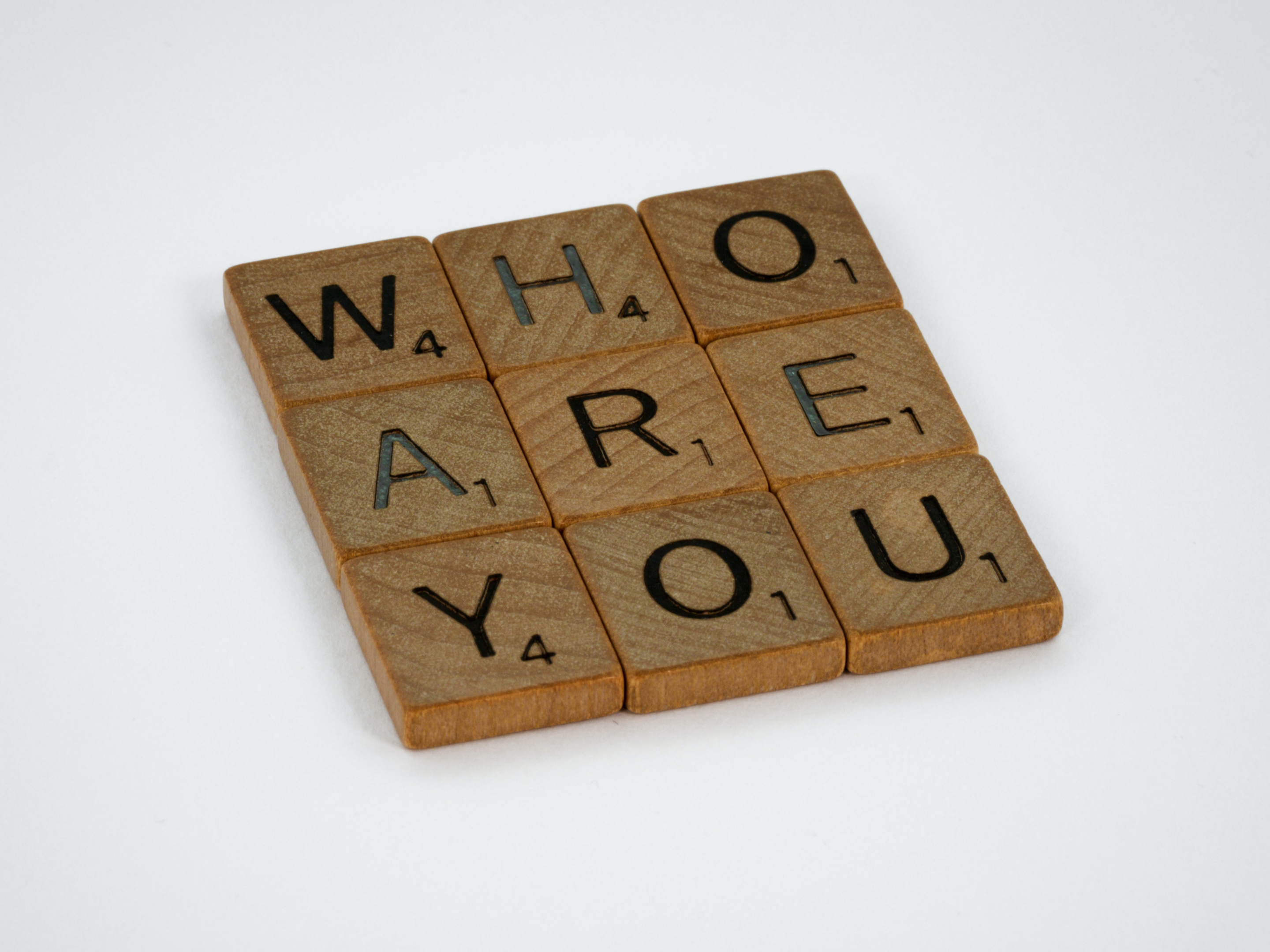 Des dès d'alphabat en bois où on peut lire la phrase "Who are you". 
L'identité de marque d'une entreprise est essentielle pour bâtir une solide image de marque.