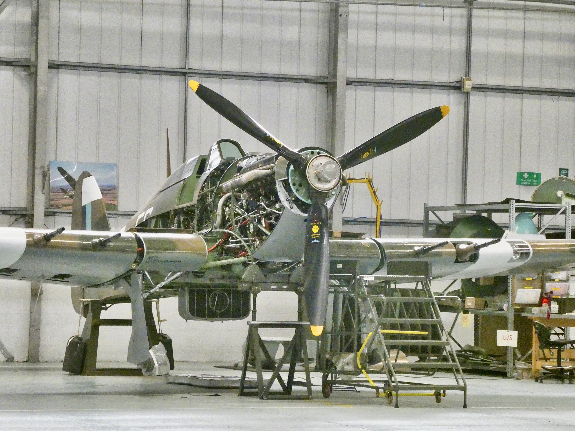 Preventive maintenance being performed on an aircraft in a hangar.
