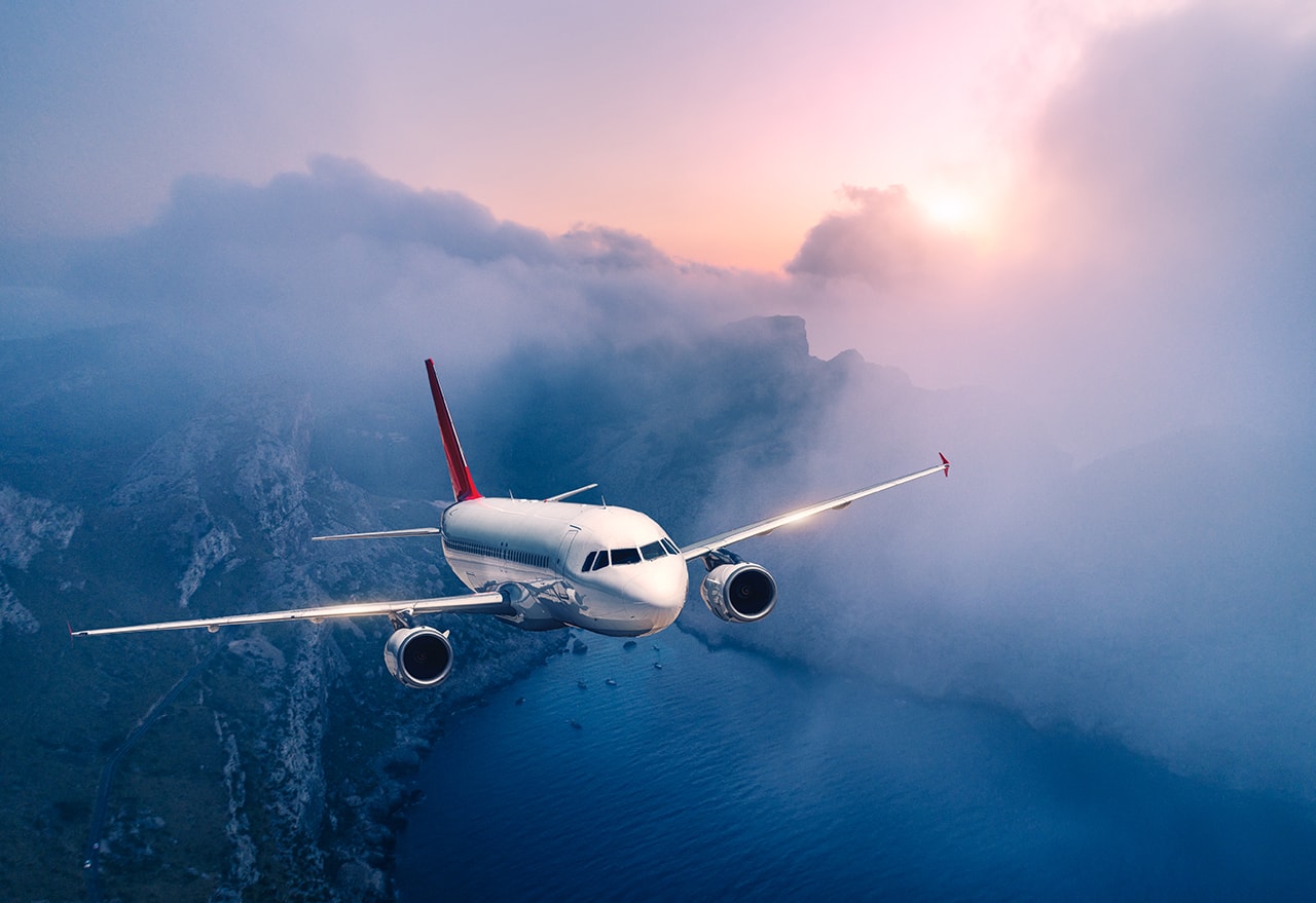 commercial airplane is flying over clouds