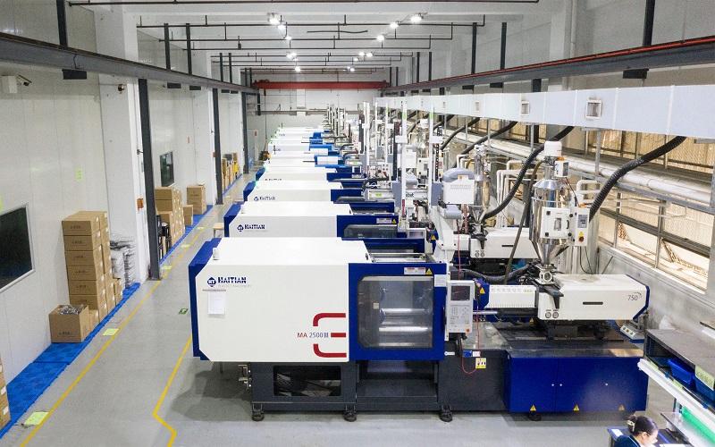 injection molding machine producing plastic parts in a manufacturing facility