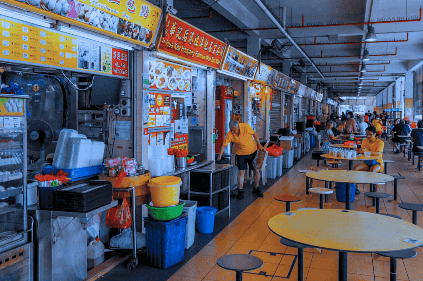 Bustling open air food court at one of Singapore’s iconic hawker centres, featuring street food vendors at brightly lit food stalls serving char kway teow with chinese sausage, hainanese chicken rice, nasi lemak with coconut milk, and other local dishes; diners enjoy hawker food at round tables near hawker stalls in a real-life scene from airport road food centre or maxwell food centre, showcasing singapore's hawker centers and hawker culture with stir fried flat rice noodles, dark soy sauce, chili sauce, and soy sauce; a must visit spot for mouthwatering food, hidden gems, and local cuisine near the singapore river, orchard road, and central business district—perfect for travel tips, blog post inspiration, and anthony bourdain-style food adventures across southeast asia.