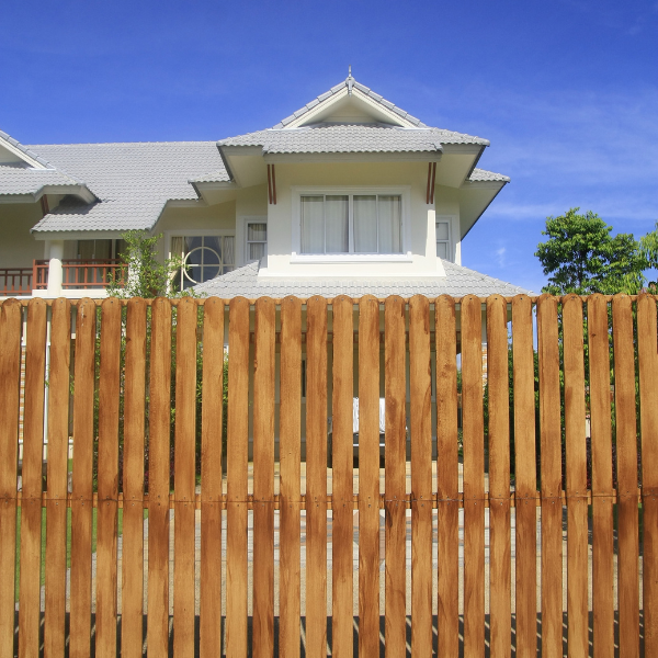 An image showing a classic wood privacy fence in a backyard.