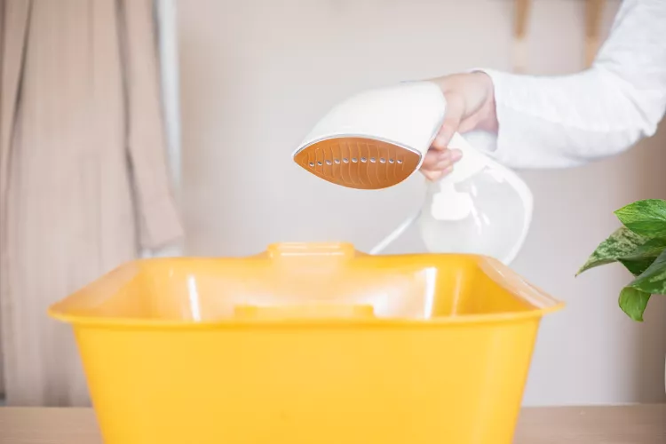 Remove the vinegar cleaning solution from the handheld steamer tank