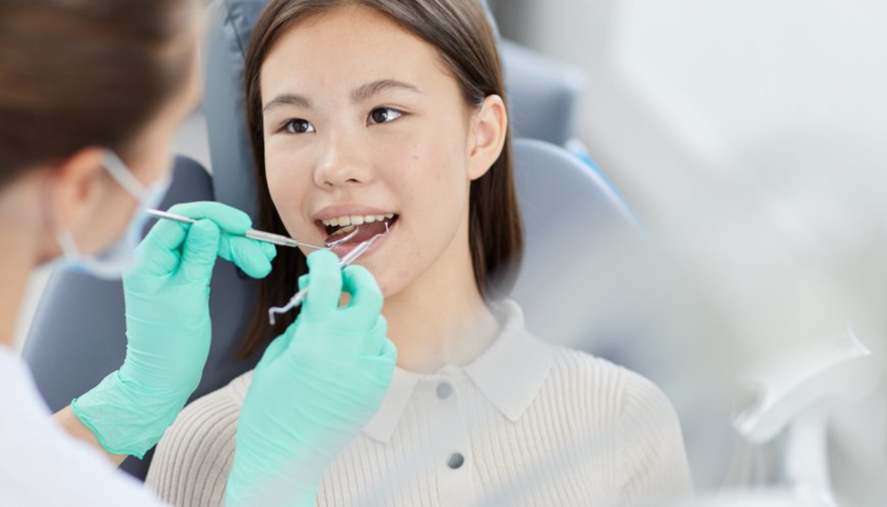 Tannhelsesekretær: Den usynlige helten bak hvert smil 9 Ung jente sitter i tannlegestol mens tannlege undersøker munnen med instrumenter og hansker profesjonelt for grundig vurdering