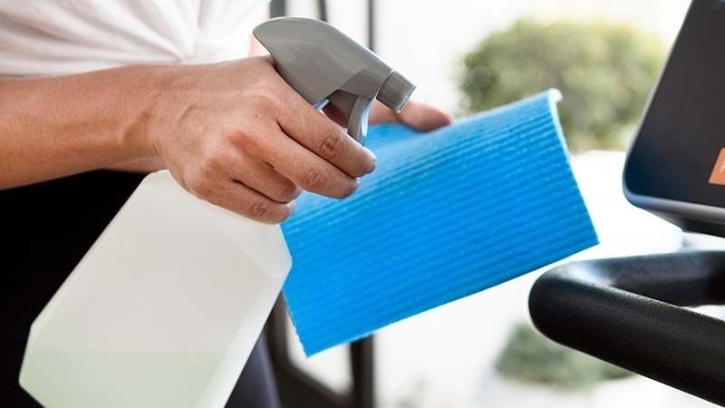 A man applying cleaner to a cleaning cloth