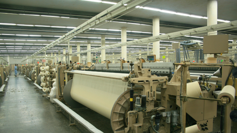 A large factory with many machines and rolls of fabric