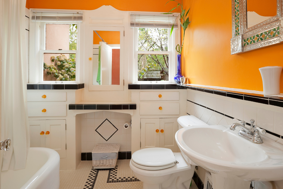 A vibrant illustration of a bathroom being painted in bright colors, showcasing budget bathroom makeover ideas.