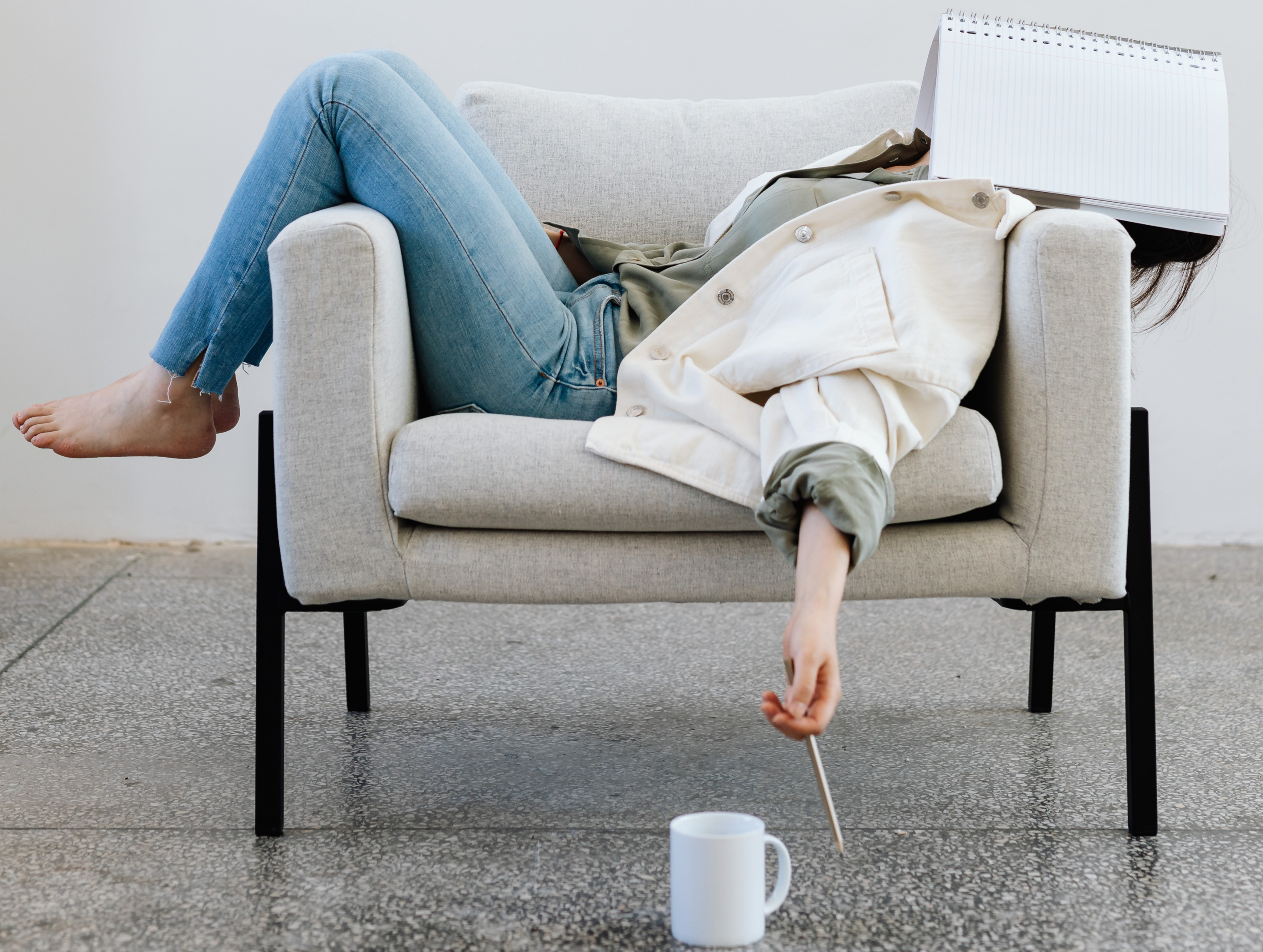 https://www.pexels.com/photo/woman-lying-on-a-sofa-with-a-notebook-on-her-face-8547448/