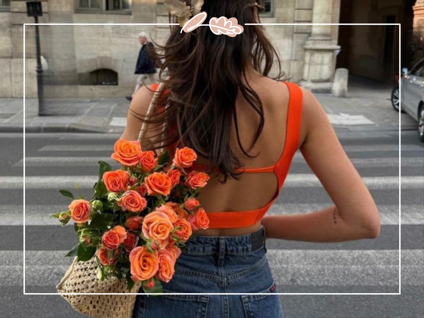 A woman in an orange top holding a bouquet of vibrant orange roses while walking down a street. Fabulous Flowers and Gifts.