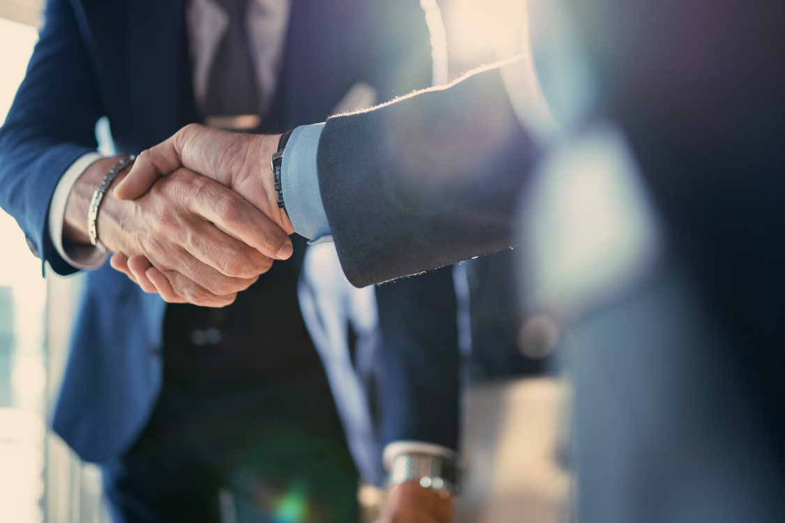 Two professionals shaking hands after finalizing a supplement supplier agreement