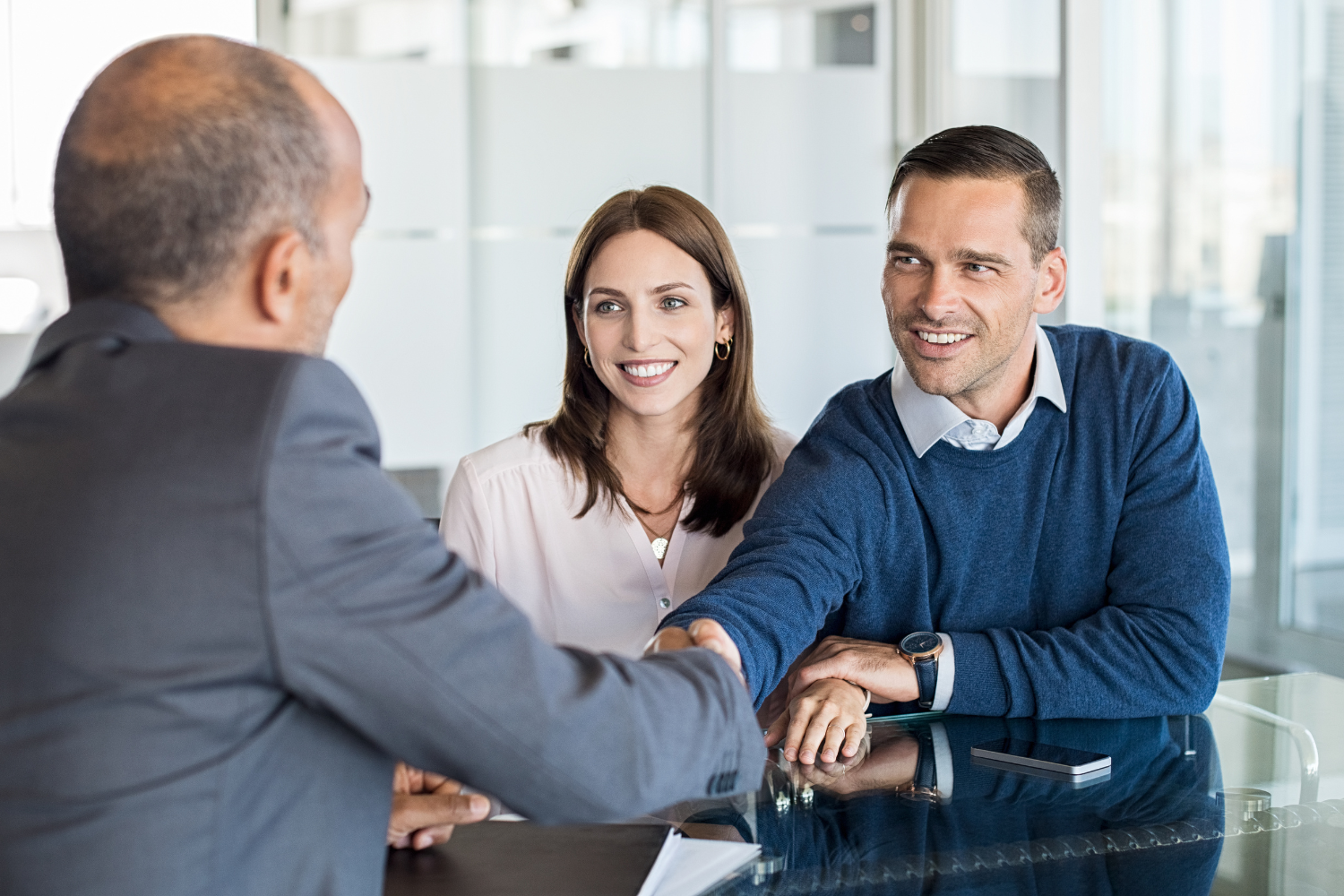 Business owners shaking hands with another professional.