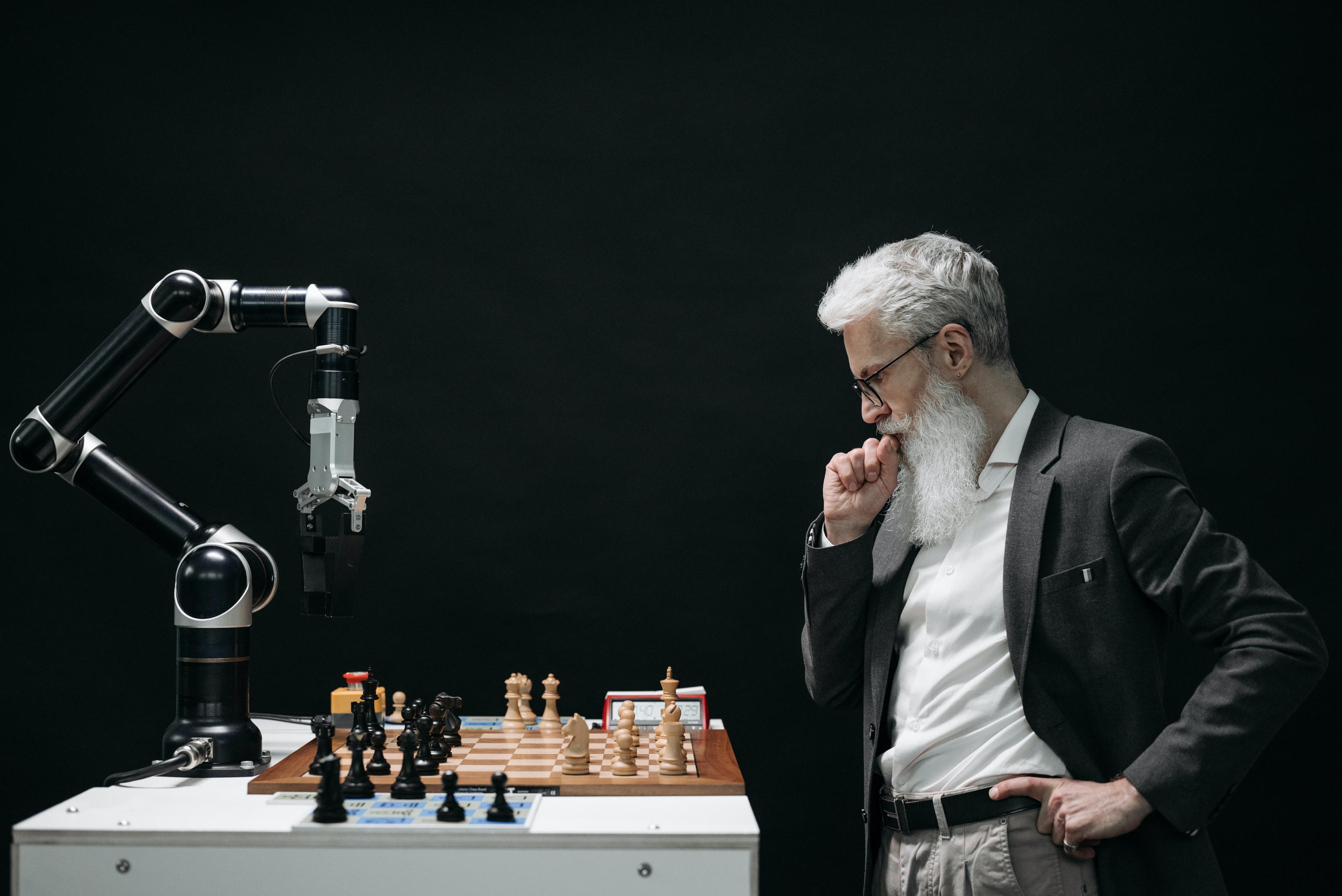 A man playing chess against a robot