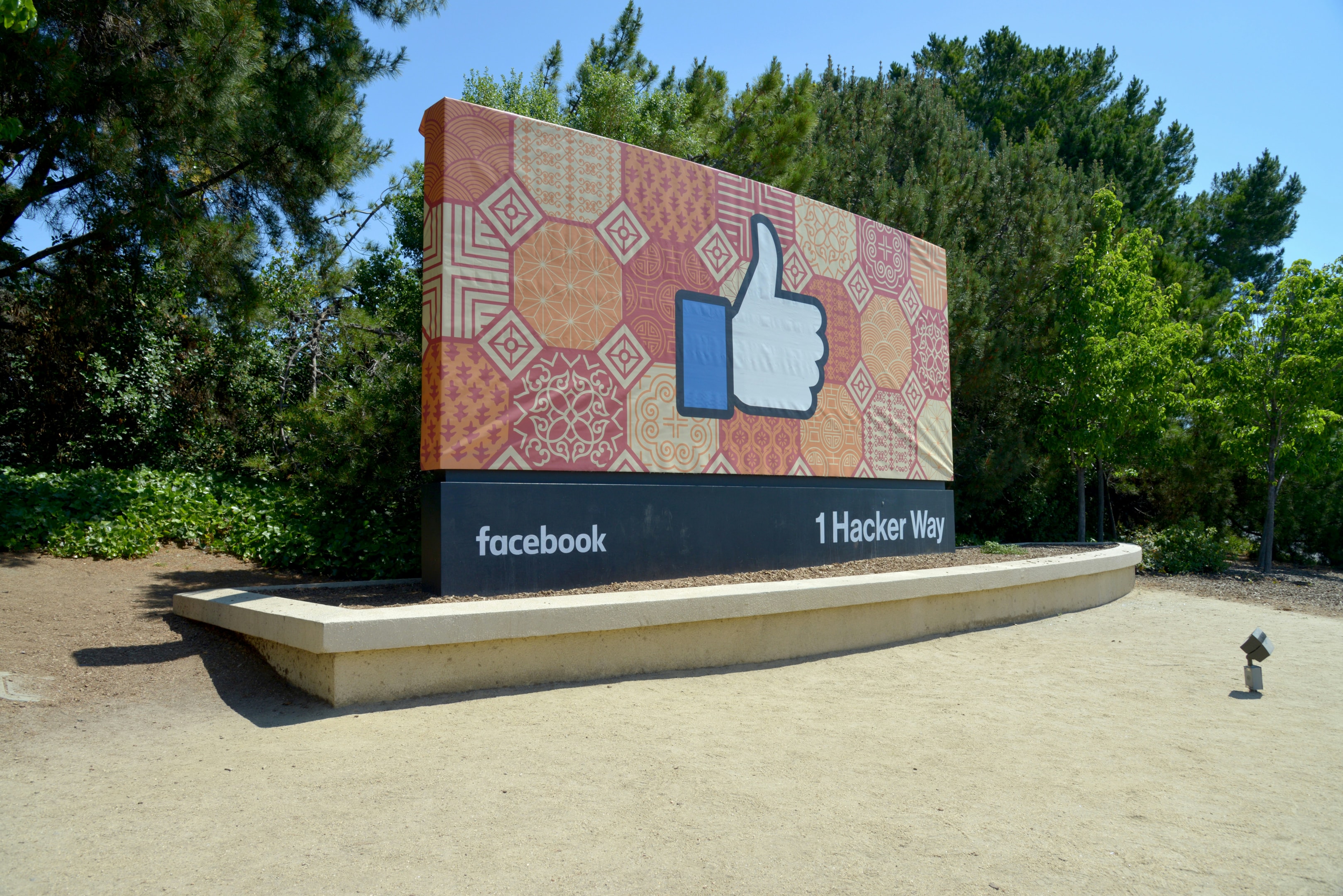 Large Facebook sign showing 'thumbs up' emoji, located outside of Facebook's headquarters.