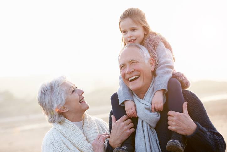 Grandparents playing with their granddaughter.