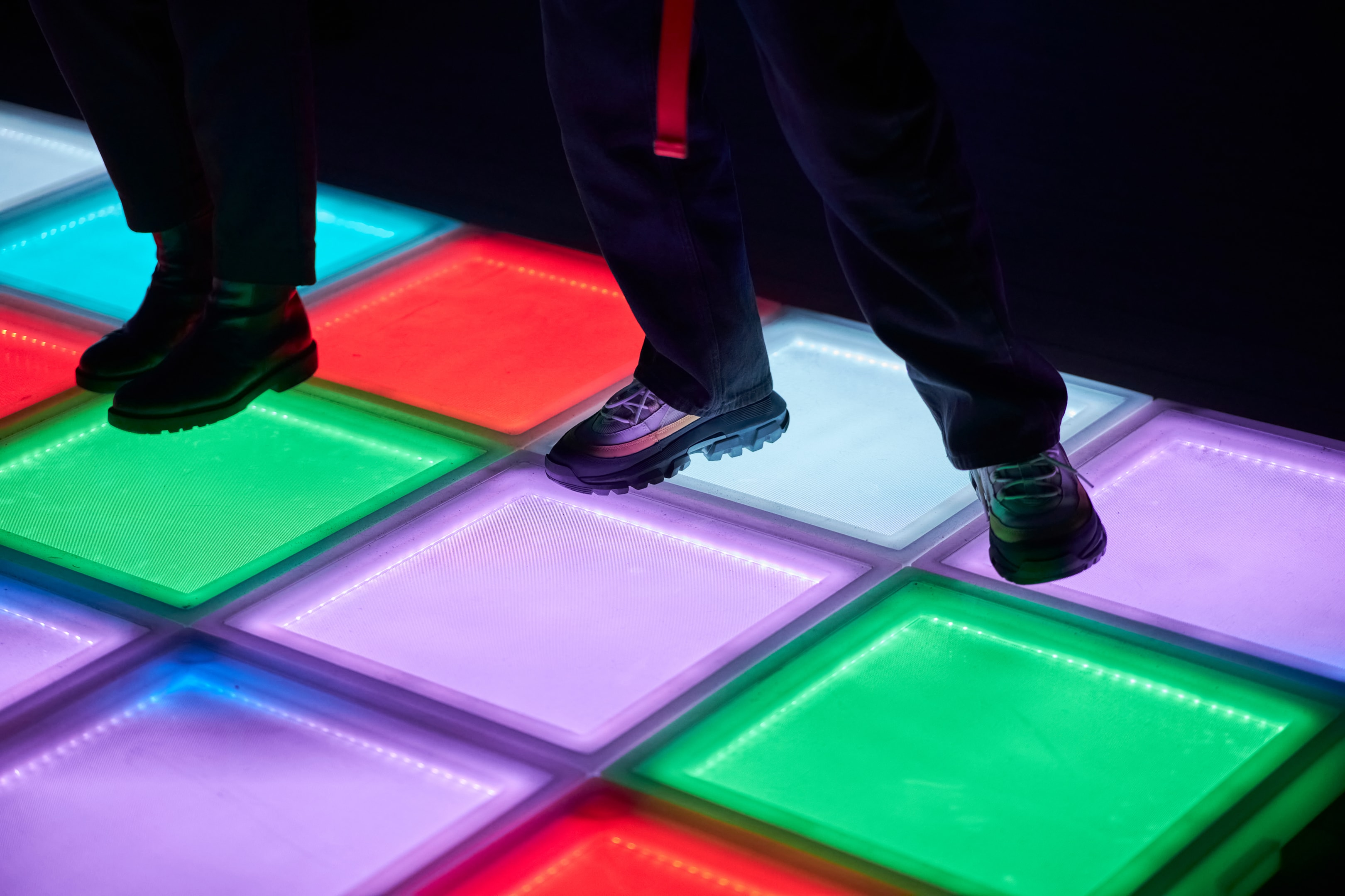 person standing on a colorful lightup dance floor