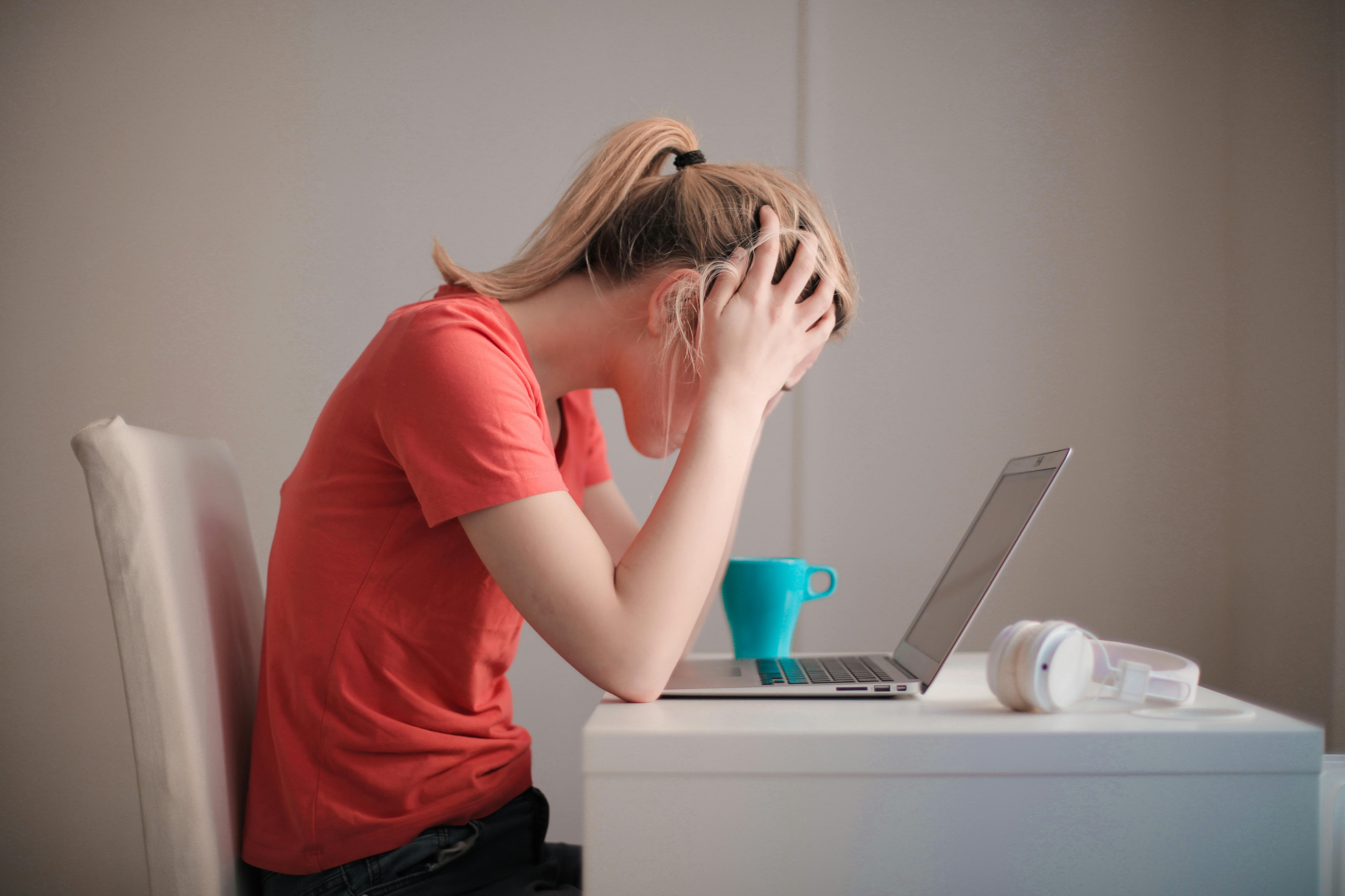 Frau zerbricht sich vor einem Laptop den Kopf