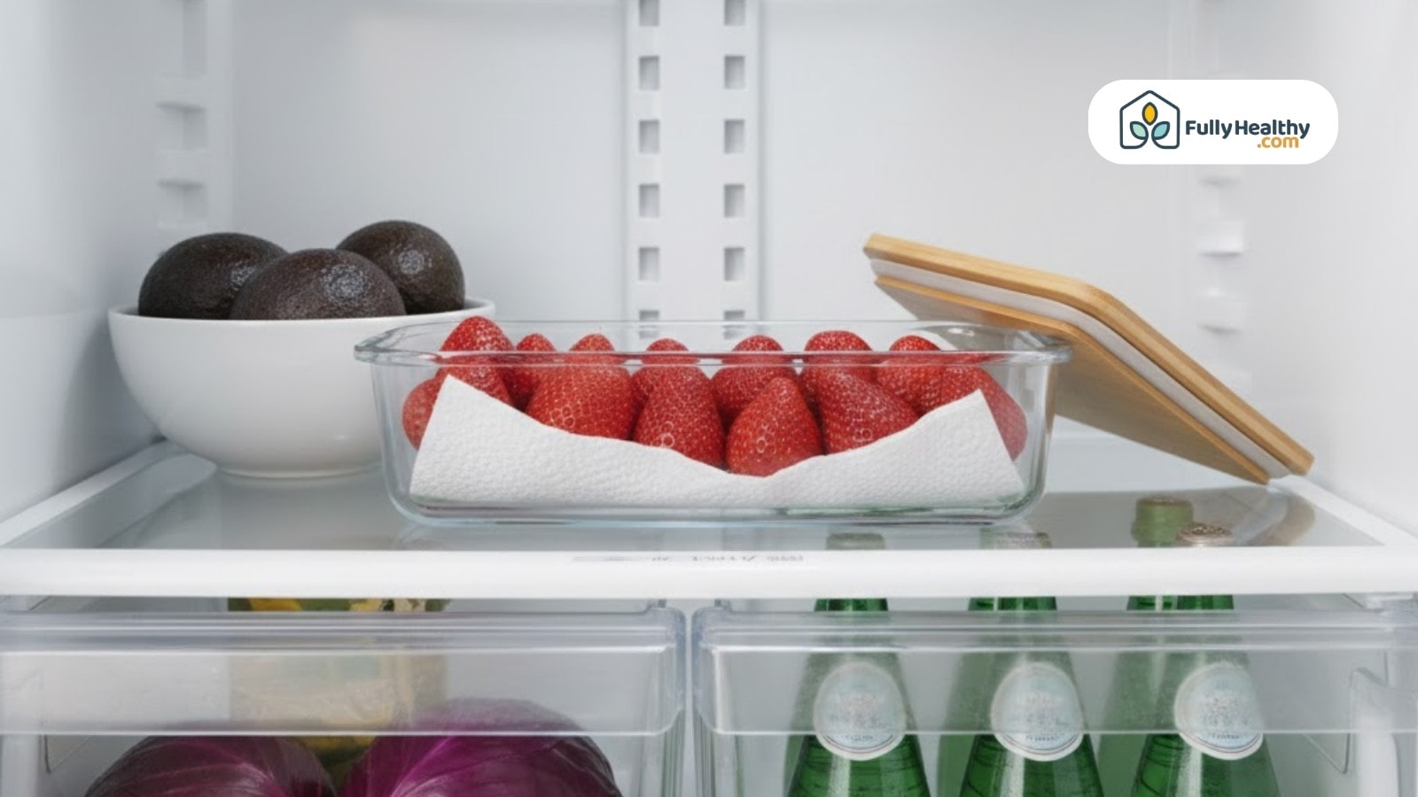 Glass container of strawberries lined with paper towel inside refrigerator