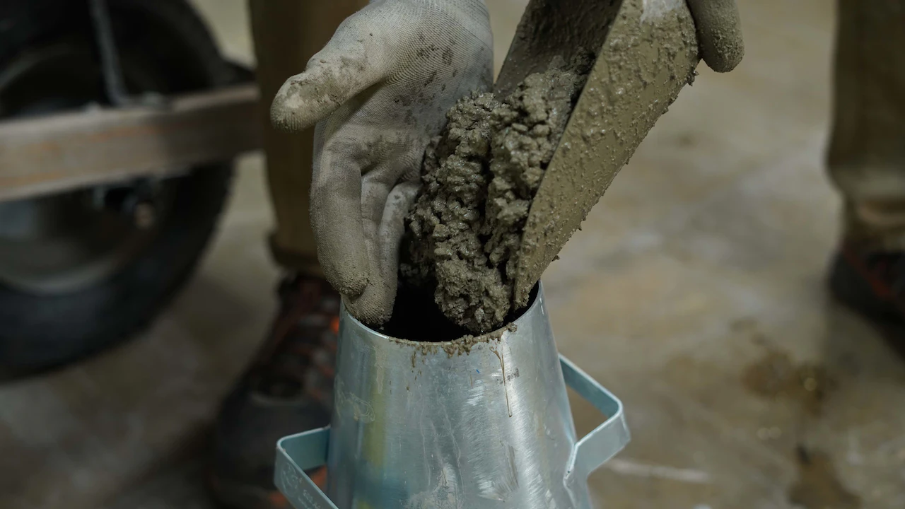 Photo of a concrete scoop filling the slump cone