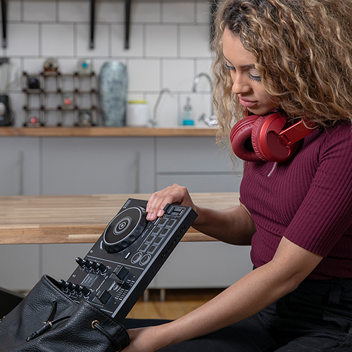 DJ loading a compact DJ controller into carry bag