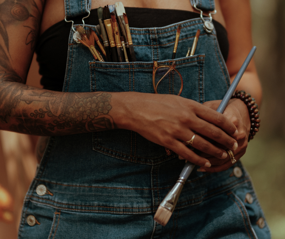 an artist holding brushes