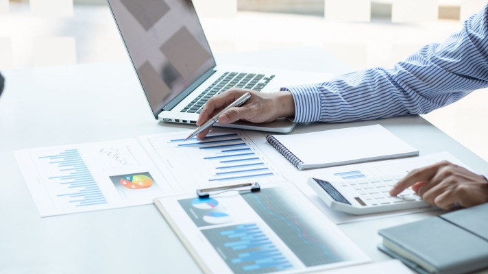 A person analyzing financial projections with a laptop