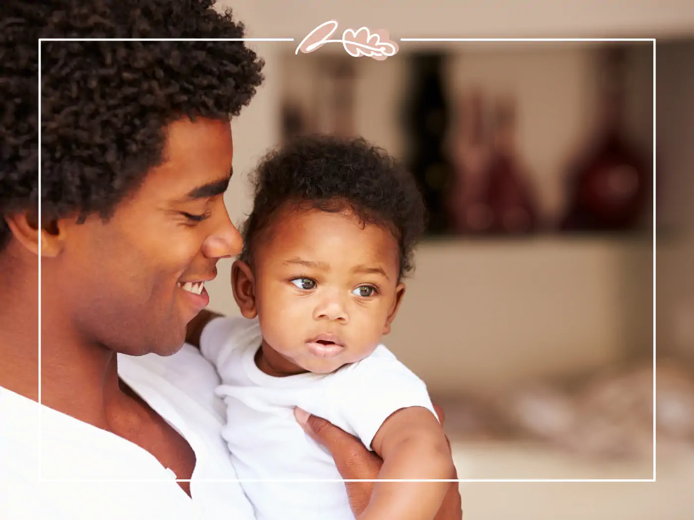 A father lovingly holding his baby, both looking content and happy. Fabulous Flowers and Gifts.