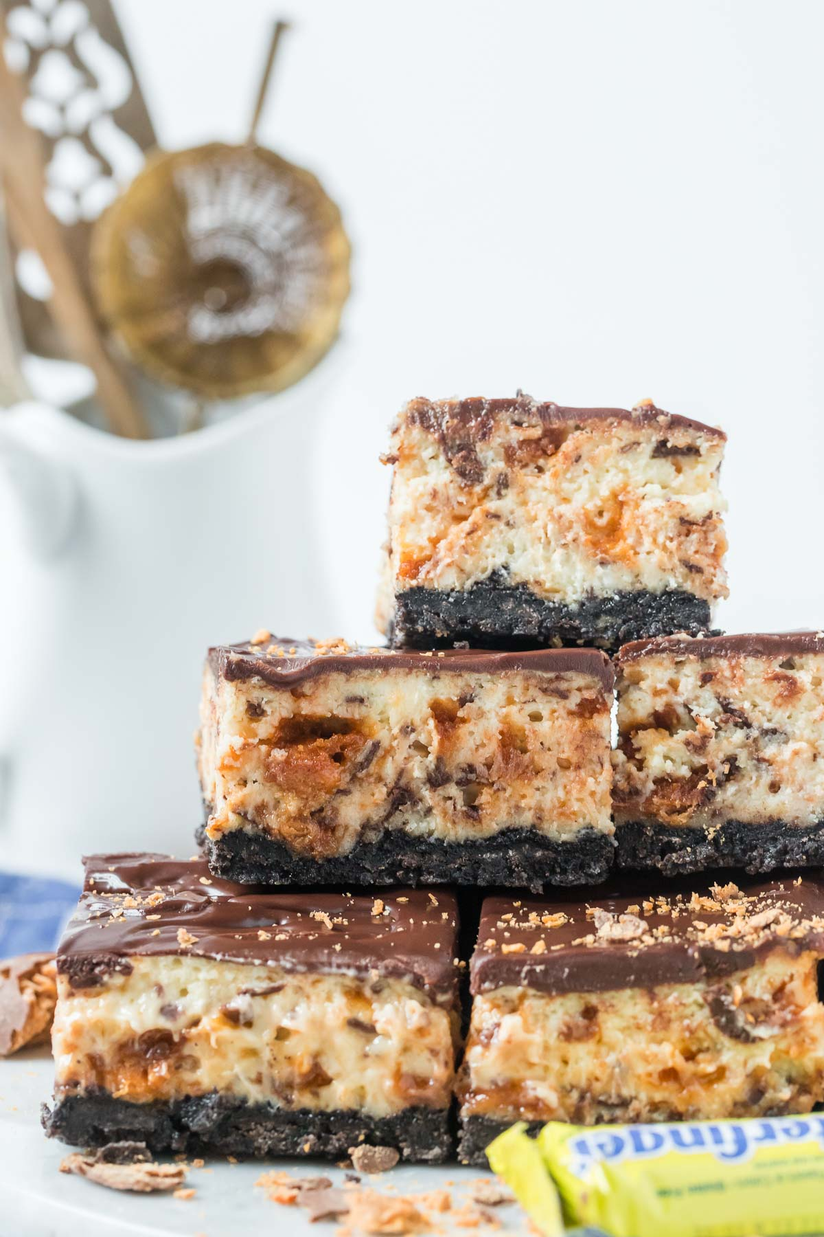 butterfinger cheesecake bars stacked on a marble board
