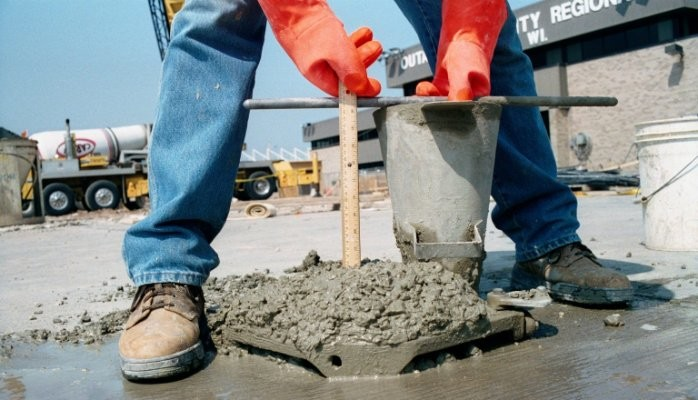 A person measuring the workability of a concrete mix