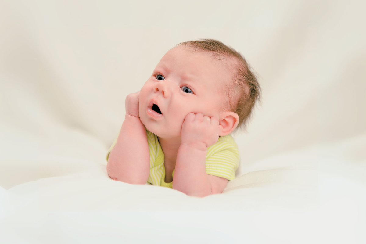 Infant hold up head with hands. Poppyseed Play